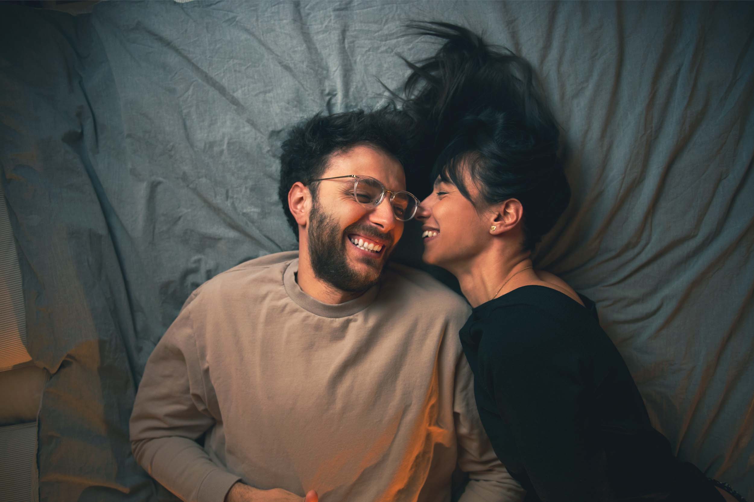A couple sitting closely, engaging in a heartfelt conversation with attentive expressions, symbolizing open communication in a romantic relationship.