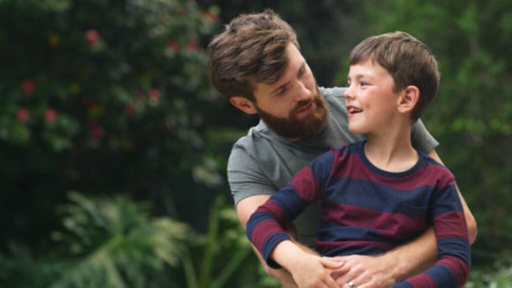 Father guiding his son while teaching values and positive masculinity